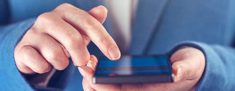Image of hands using a mobile phone used in article about facebook advertising